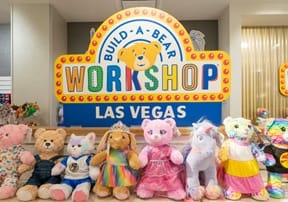 A row of stuffed animals in front of the Build a Bear Workshop Las Vegas sign